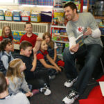 NFL quarterback reads to excited first graders