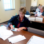 Volunteer envelope stuffers seal their service