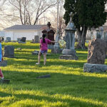 Youths ask questions during cemetery cleanup
